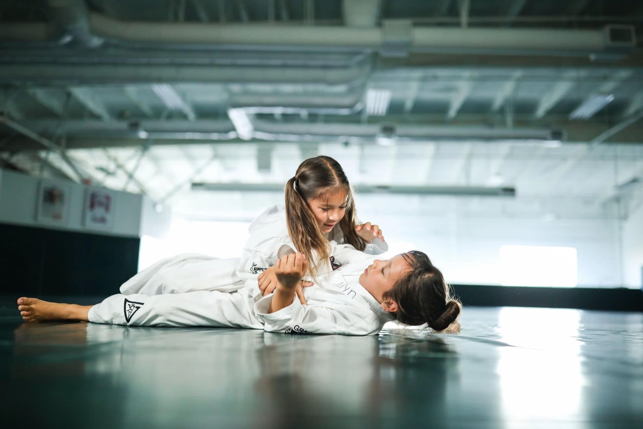 A child and instructor laughing during a Gracie Bullyproof class